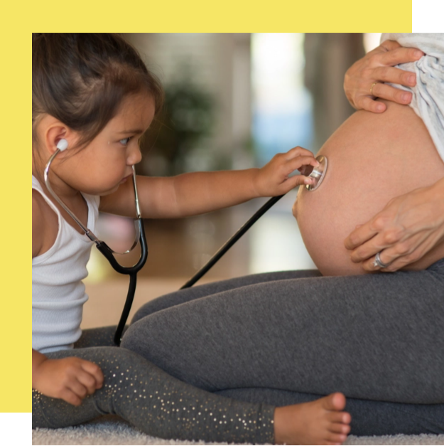 girl placing stethoscope on pregnant woman